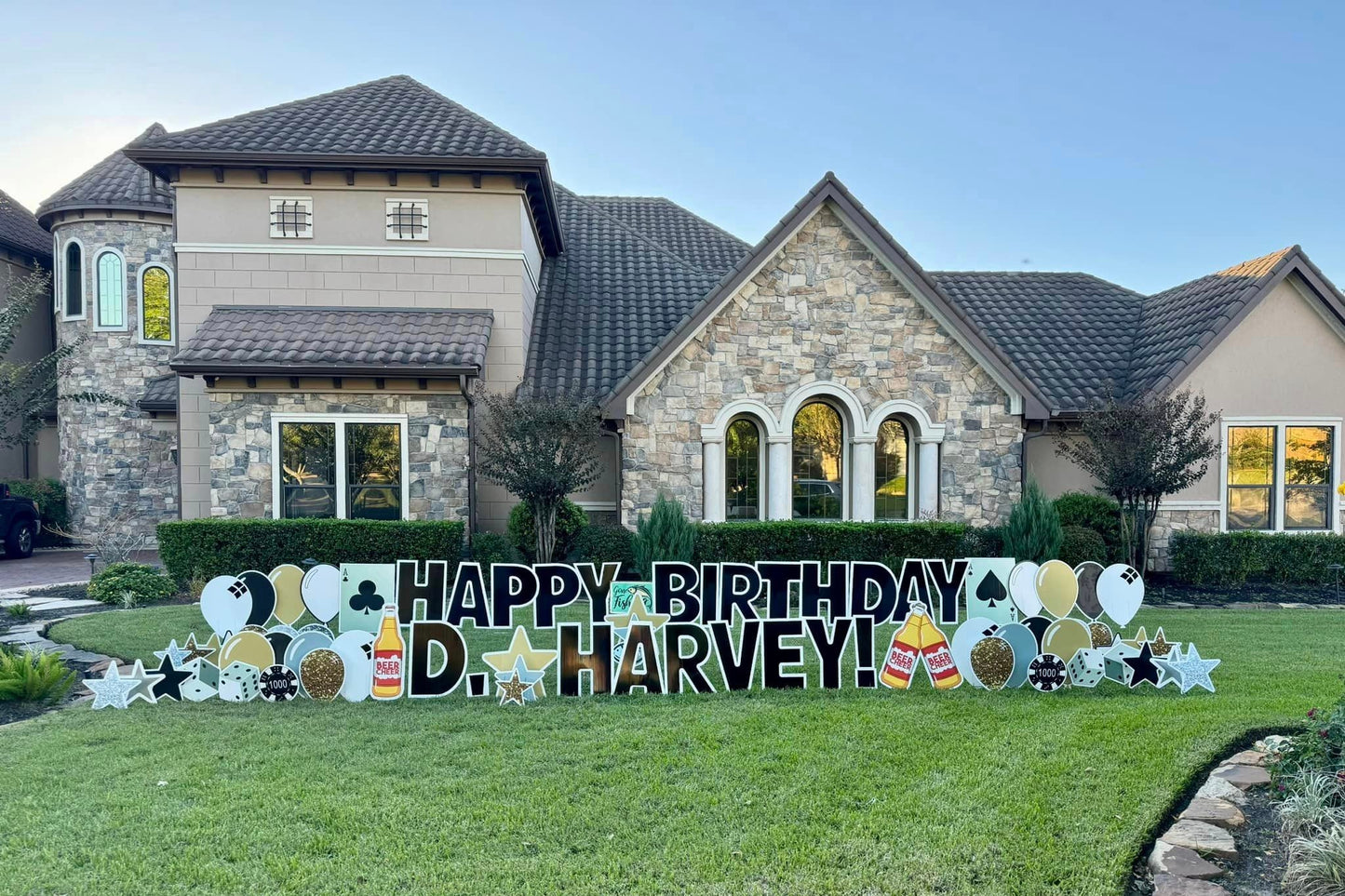 A stylish yard card display by Texas Party in the Yard, perfect for celebrating an adult's birthday. The setup includes a custom "Happy Birthday" message, the celebrant's name, elegant balloons, stars, and poker and beer graphic images, set up in a front yard in Conroe, TX.