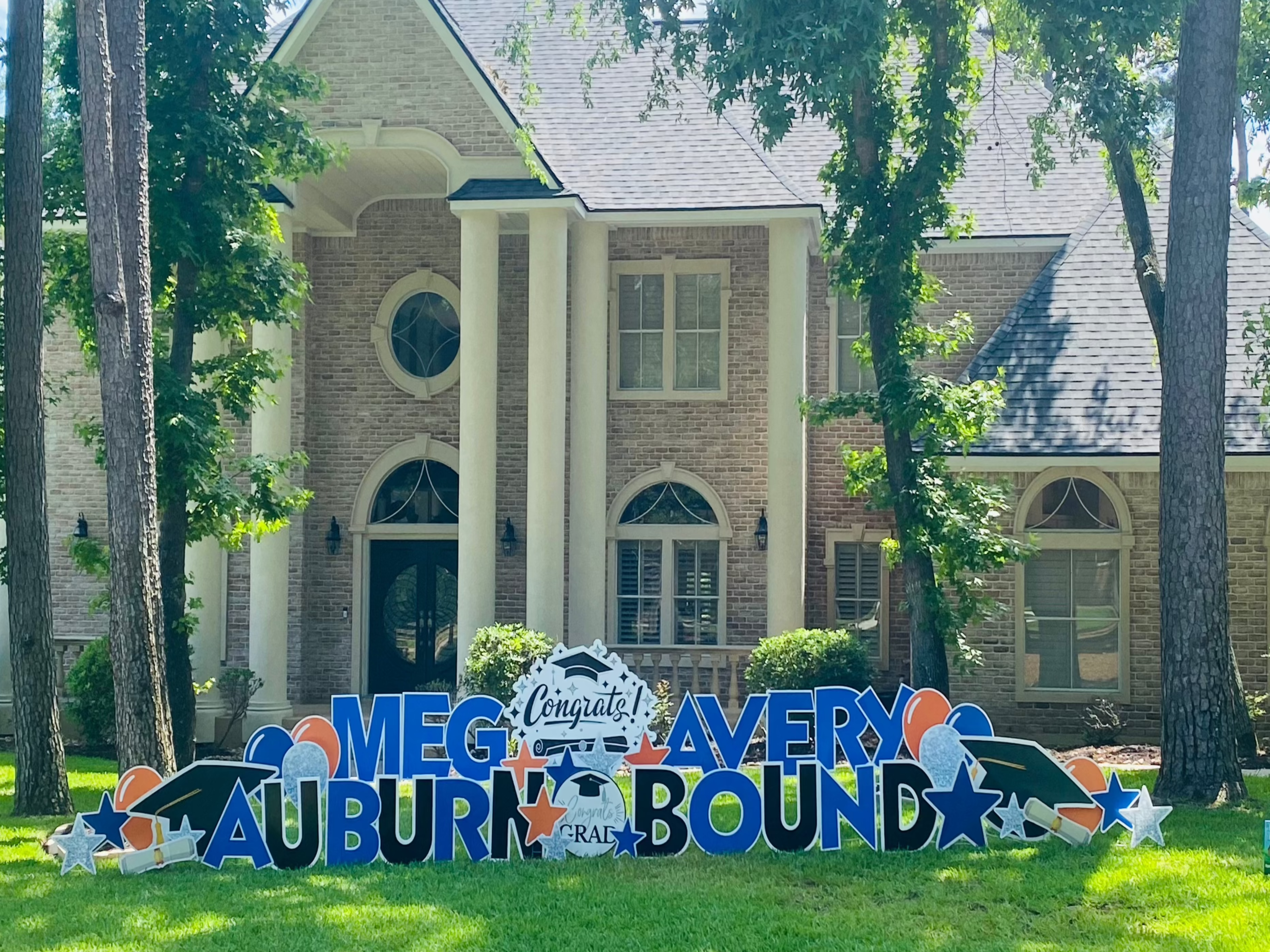 Our deluxe graduation yard card in Auburn colors, clebrating two high school grads, in blue and orange graphics. Graduation hats, diplomas, balloons and stars in Auburn colors round out this bold, eye-catching graduation sign. Montgomery, Tx