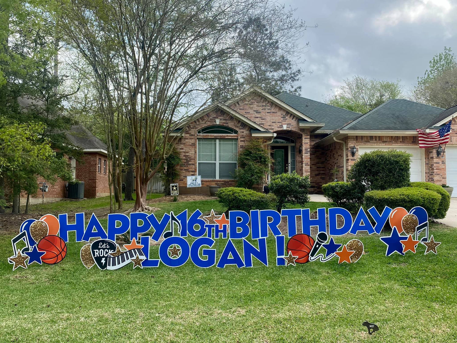 A cool yard card display by Texas Party in the Yard, celebrating a boy's 16th birthday. The setup includes a "Sweet 16" message with his name, sports-themed graphics, cars, and vibrant balloons, arranged in a front yard in Montgomery, TX.