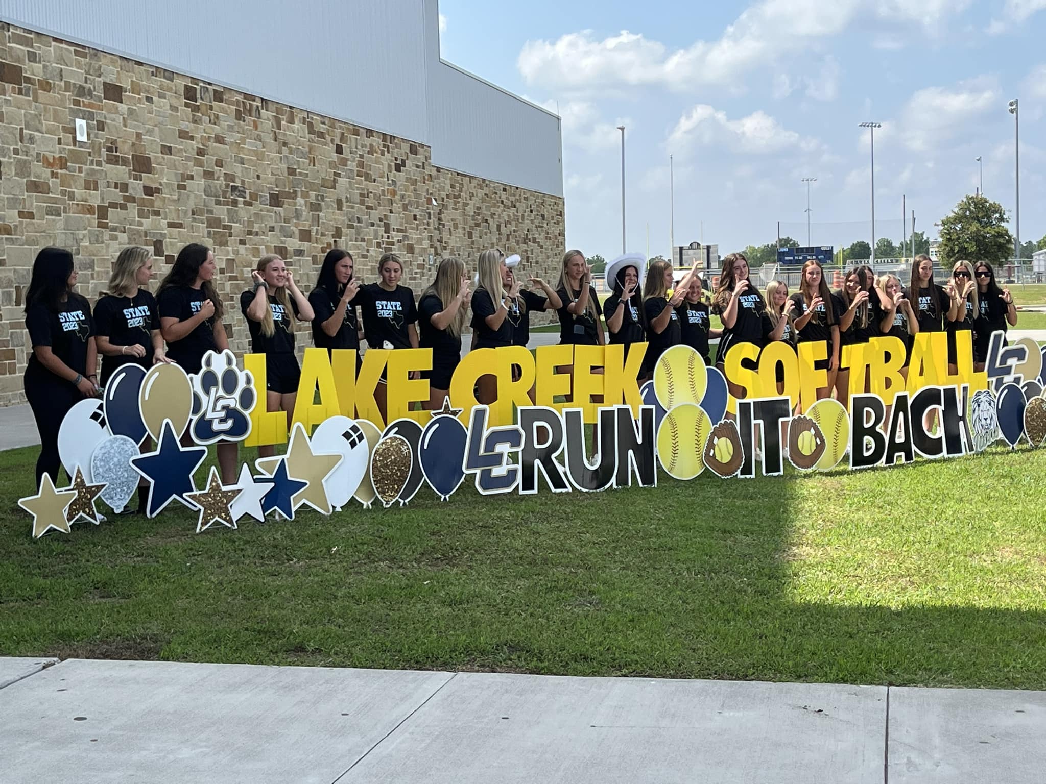 Lake Creek High School softball team celebrating the playoffs with custom yard card graphics in team colors, Montgomery, TX