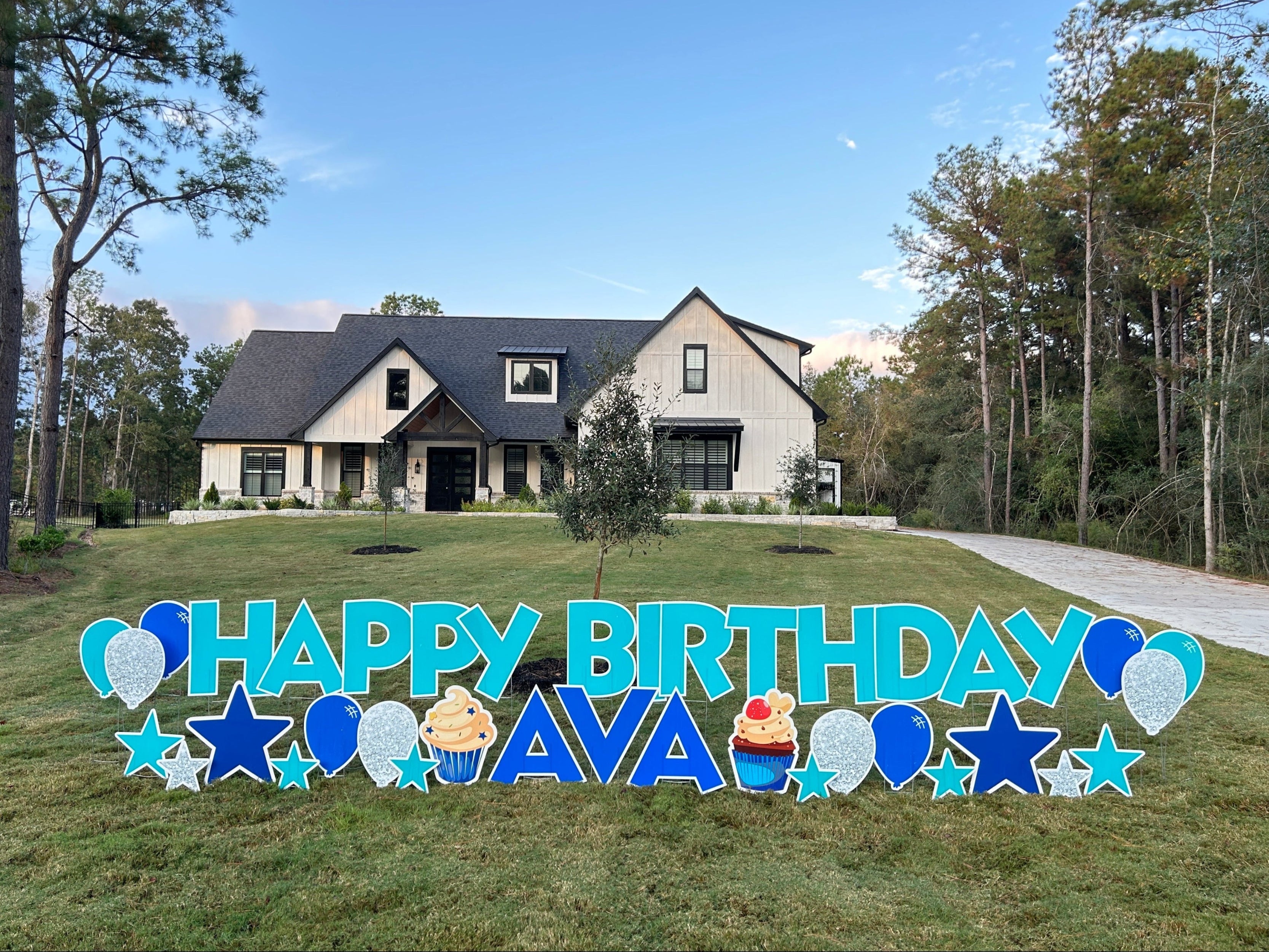 A vibrant Happy Birthday yard card display in Montgomery, TX, featuring letters in shades of vibrant blues, festive balloons, and shining stars. The perfect way to celebrate a special day with a fun and eye-catching outdoor setup!