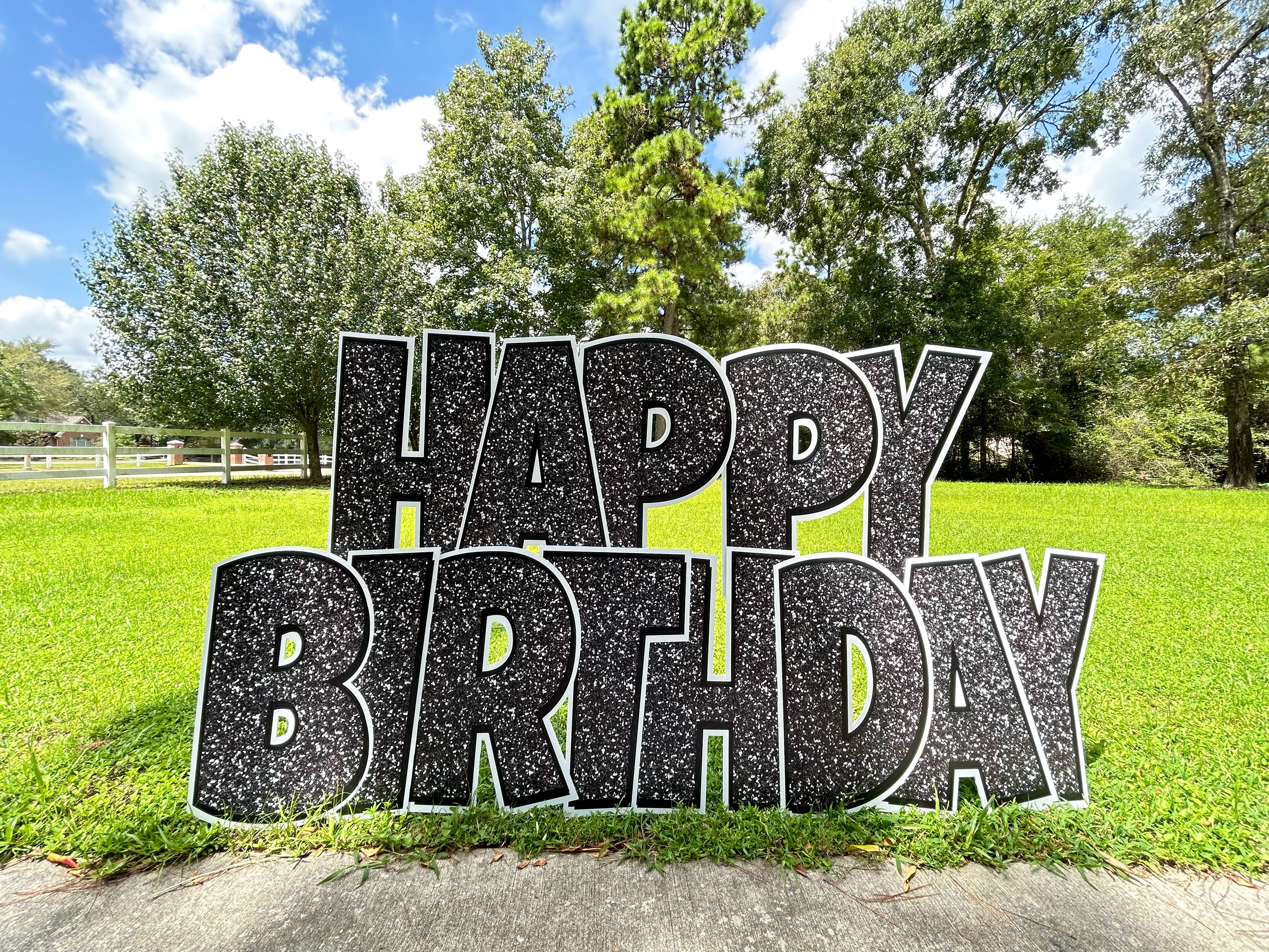 A festive display of Texas Party in the Yard's birthday flash signs, featuring black glitter 