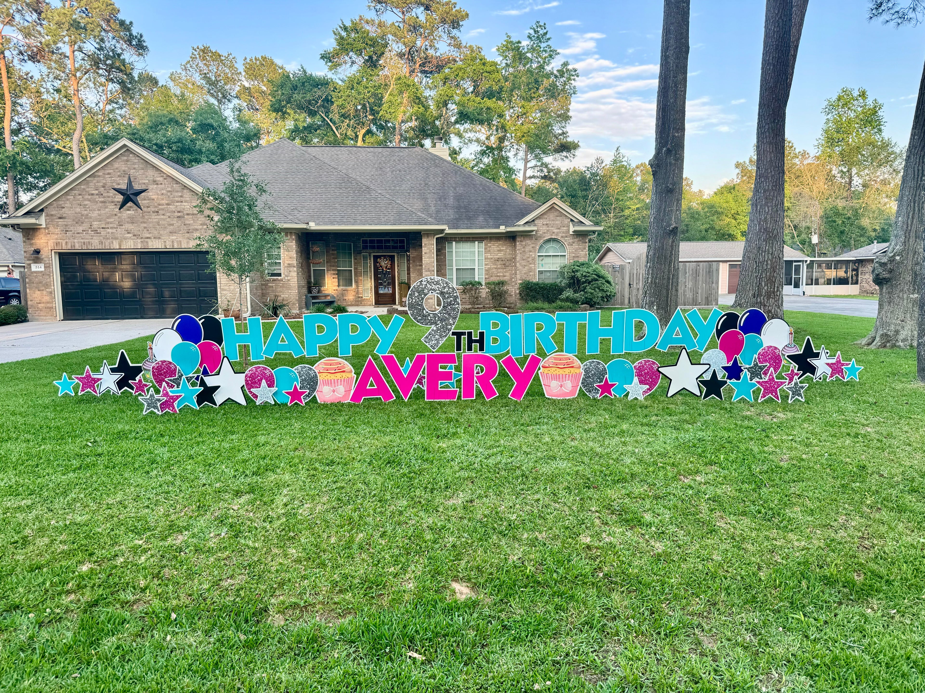  A fun and colorful yard card display by Texas Party in the Yard, celebrating a child's birthday. The setup includes a "Happy Birthday" message, the child's name, balloons, stars, and playful graphic images like cupcakes and presents, arranged in a front yard in Conroe, TX.